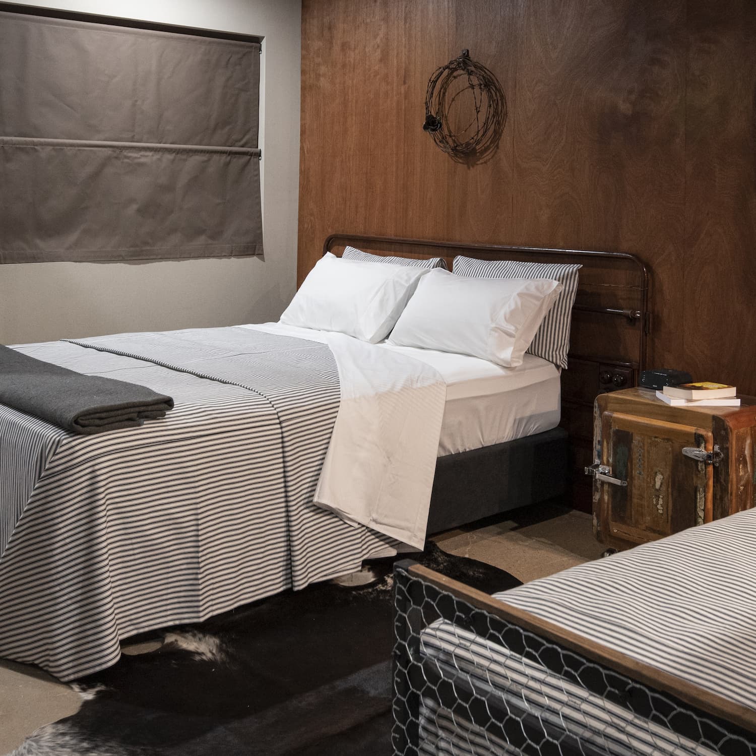 The Stables room interior with Queen bed, timber wall panelling and cow hide rug