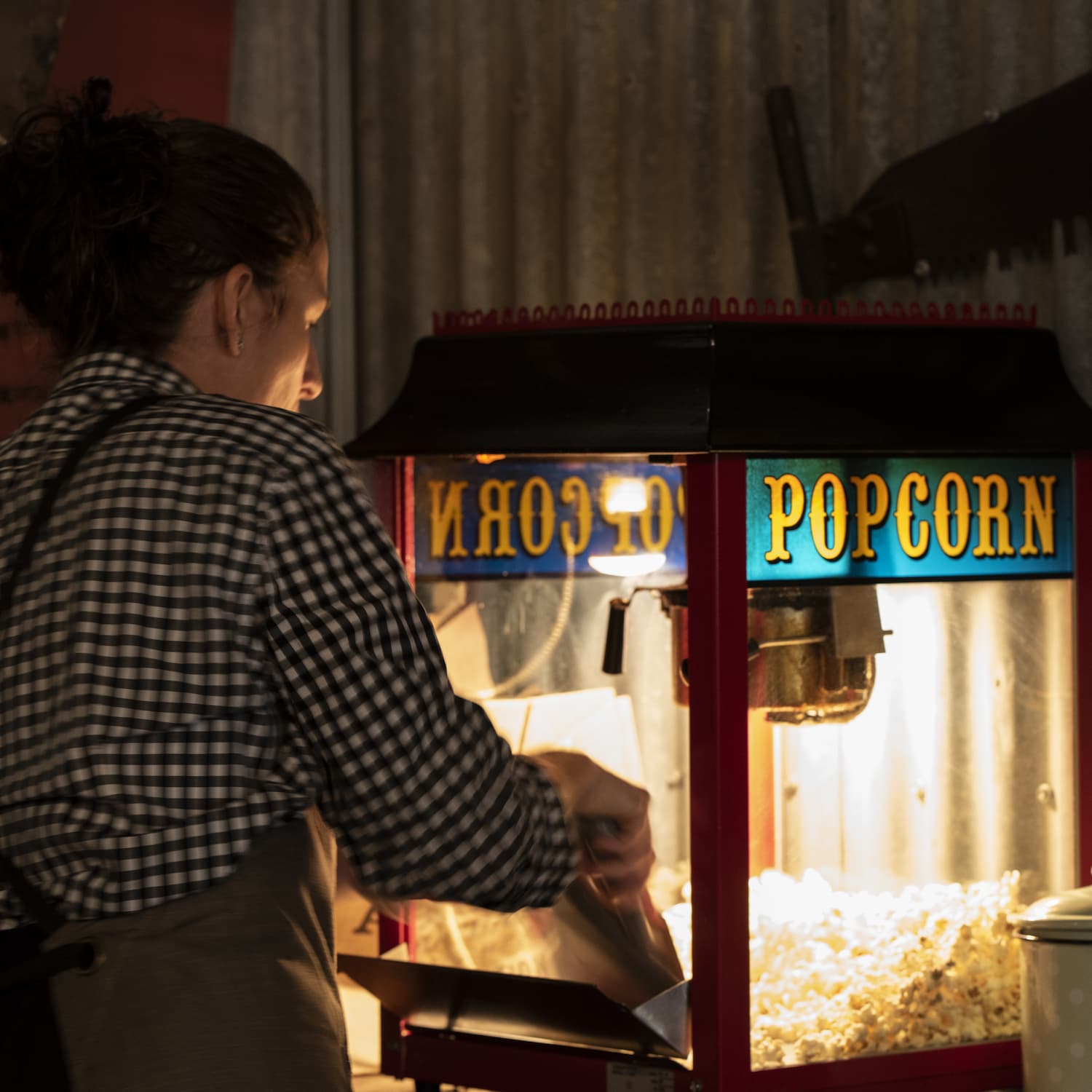 Waitstaff standing at a popcorn making machine