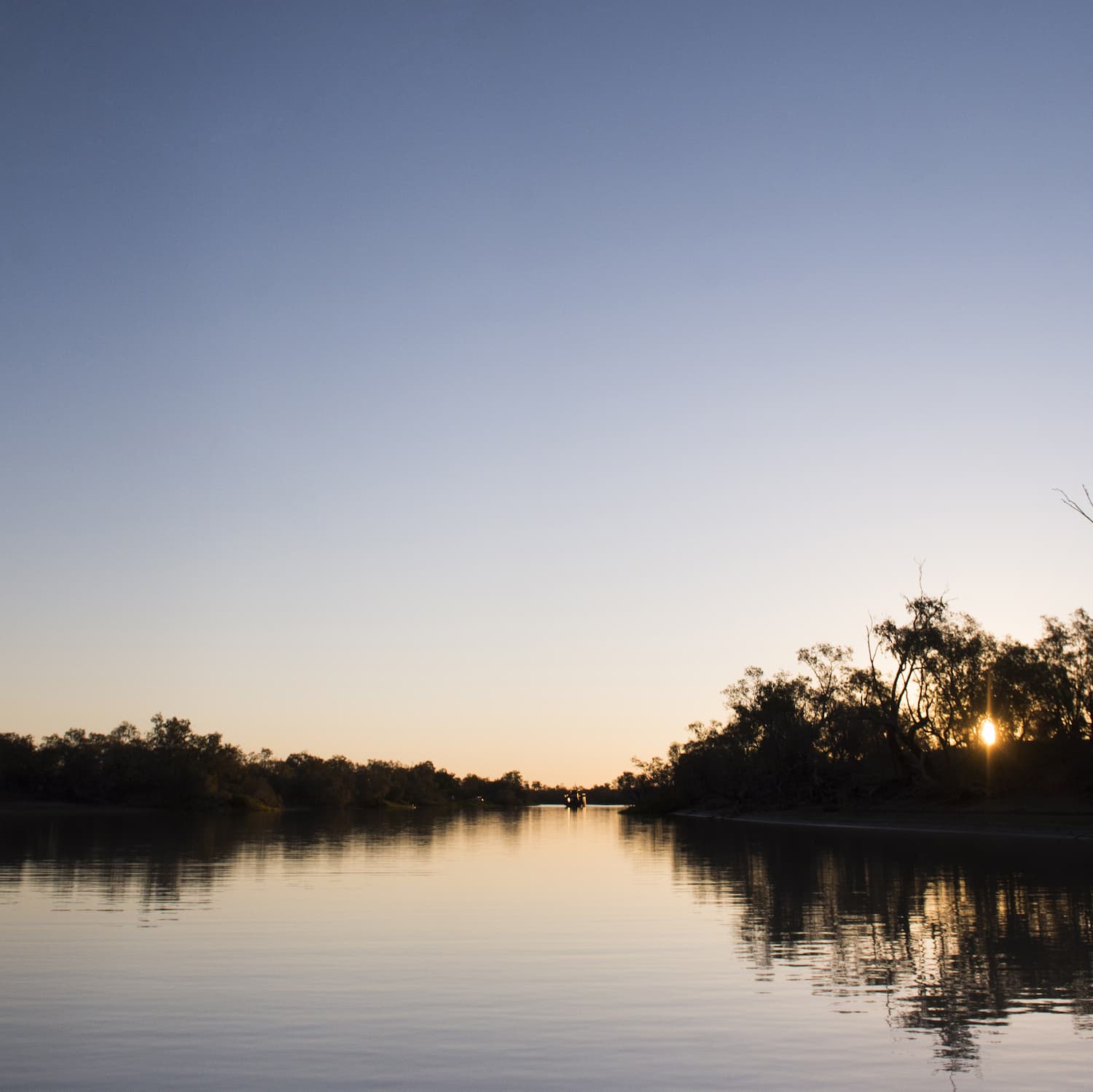 Expansive view of the Thomson River at dusk. Thomson Belle Paddlewheeler visible in the far distance