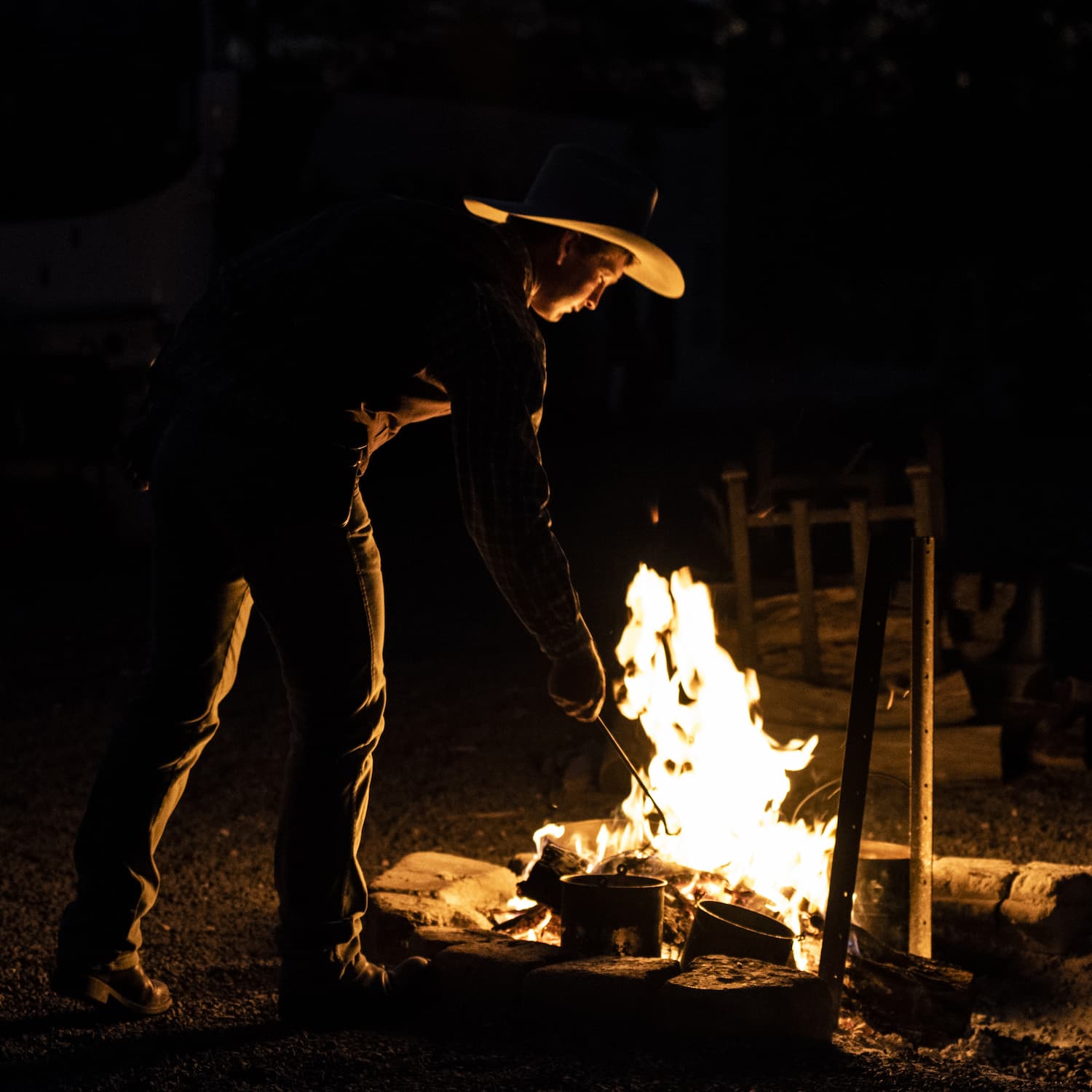 Stoking the camp fire in the black of night