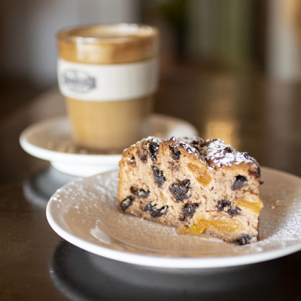 Piece of fruit cake with coffee in the background