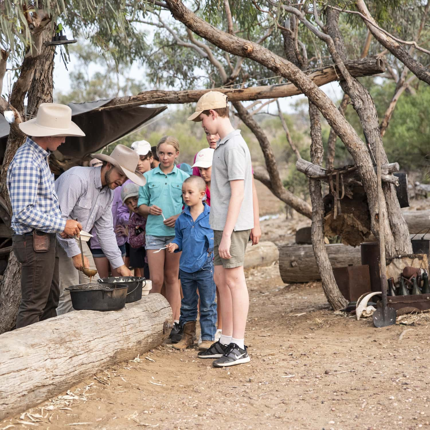 Serving stockman's stew to students in a bush setting