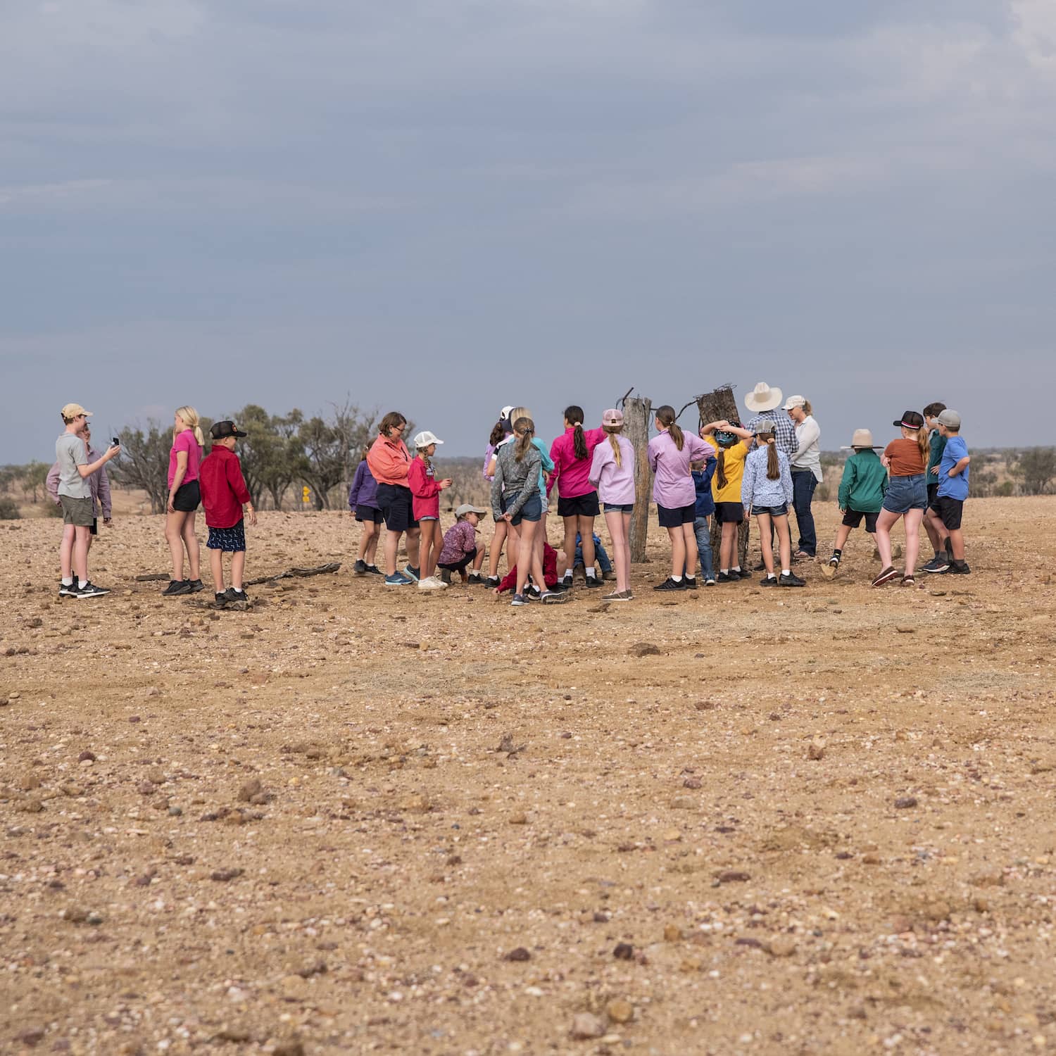 Students standing together on an outback ridge at dusk
