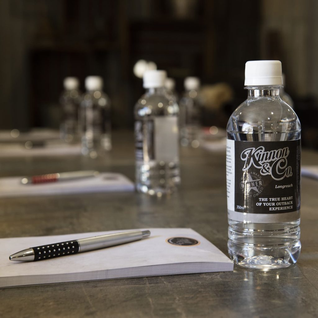 Conference table setup with notepad, pen and bottle of water