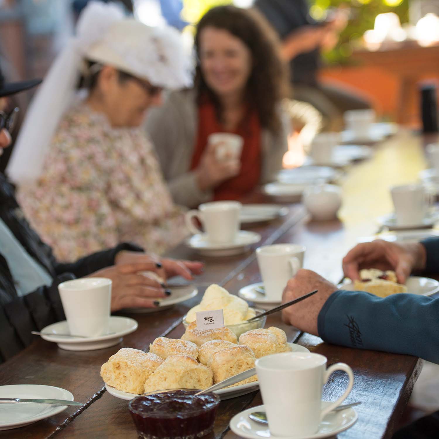 guests in the background out of focus enjoying brunch. The image is focussed on a plate of scones