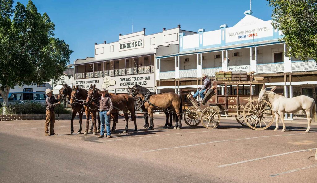 Horses and stagecoach standing outside heritage buildings on Eagle St, Longreach